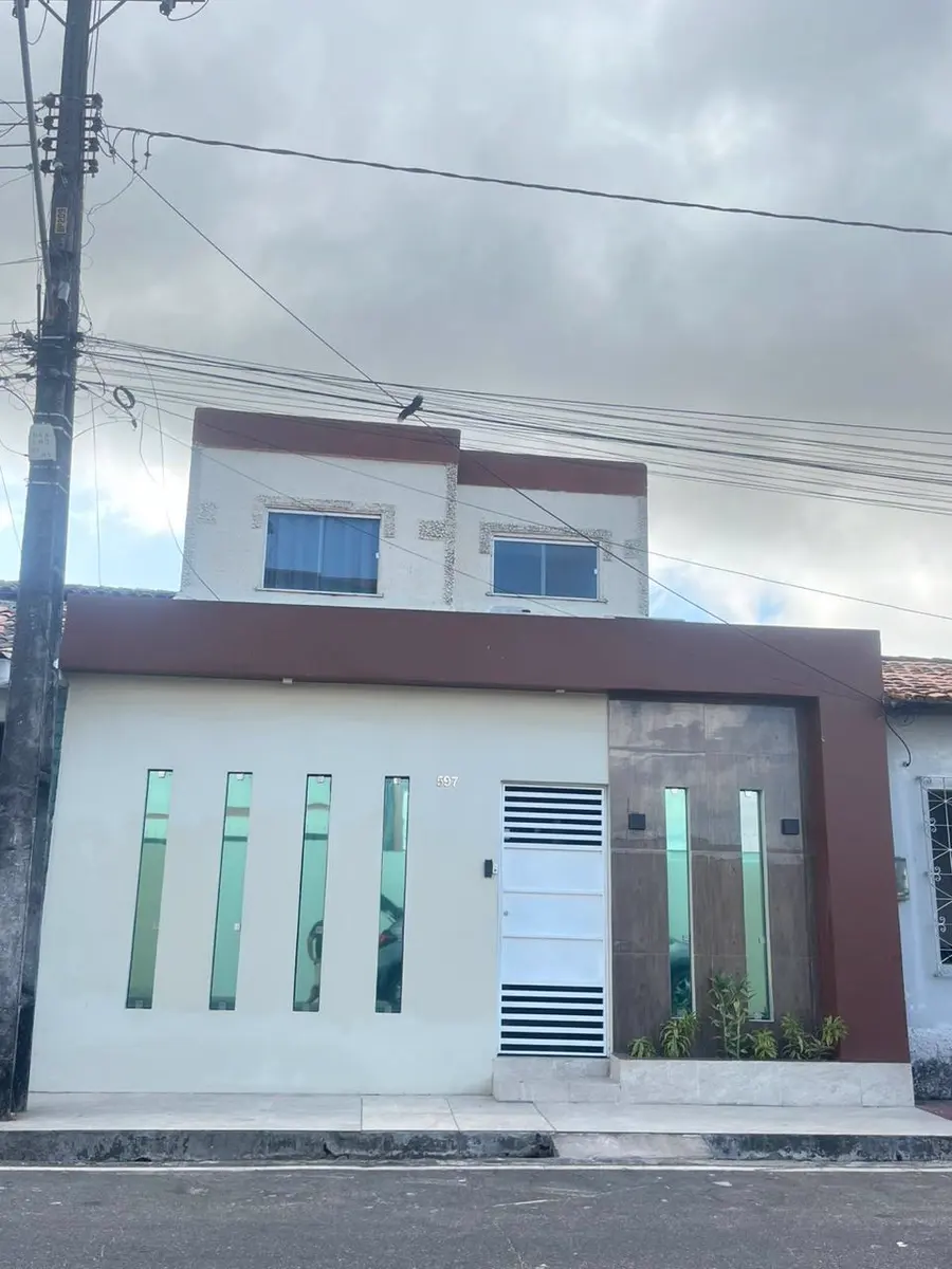 Fachada do consultório, um sobrado branco e marrom